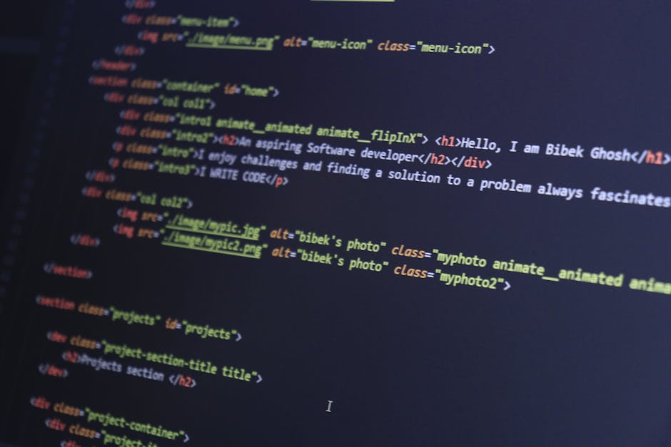 A close-up photograph of a computer screen displaying lines of HTML code in various colors including blue, yellow, red, and white on a dark background. The code includes tags such as '<h1>', '<div>', 